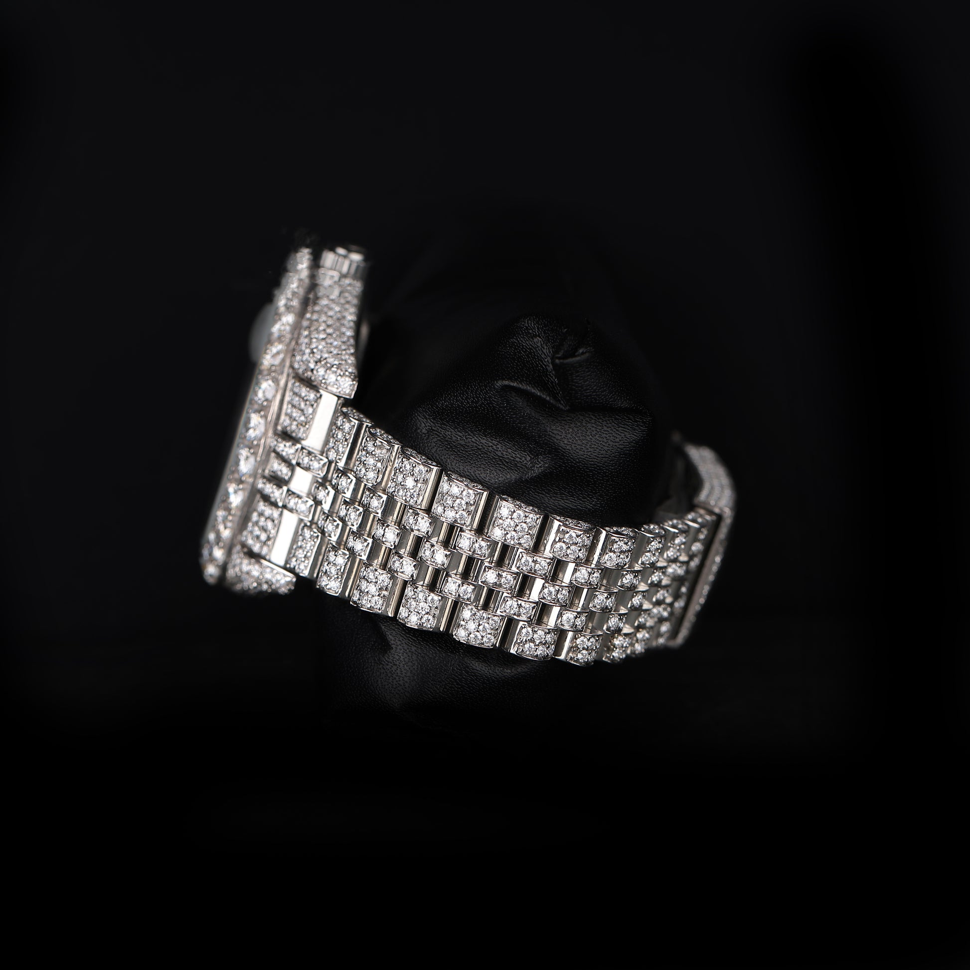 automatic luxury watch with full stone setting and round dial close up